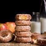 Baked Apple Cider Donuts stacked with bite out of top