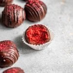 Chocolate-Covered Red Velvet Cake Truffles with a bite missing out of one cake ball