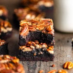 Pecan Pie Brownies stacked on top of each other with a bite missing