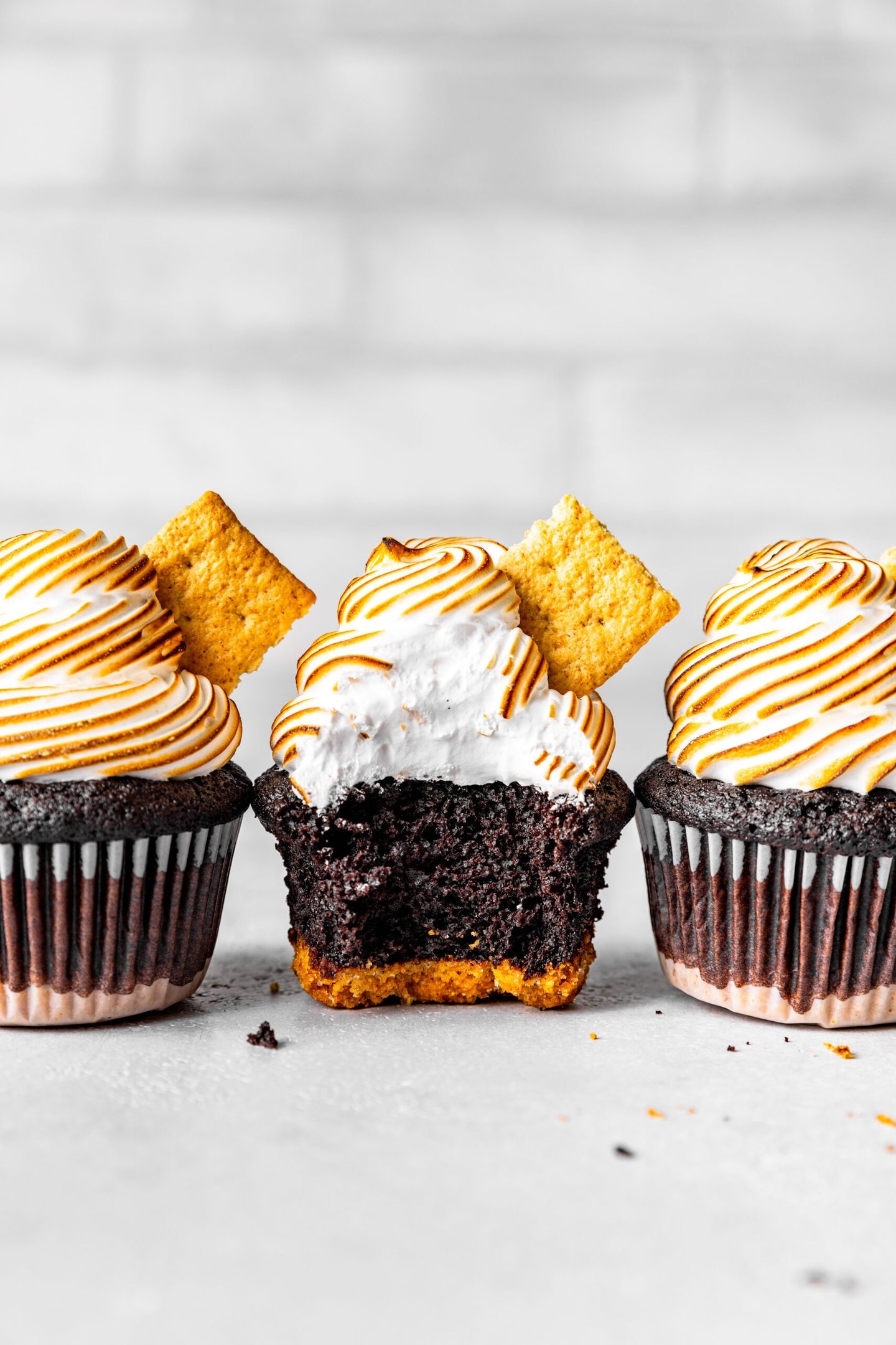 Marshmallow meringue frosting on top of s'mores cupcakes