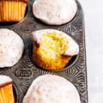 Lemon Poppy Seed Muffins in a muffin tin with a bite missing from one muffin