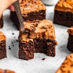 Fork removing a bite from a slice of moist chocolate cake.