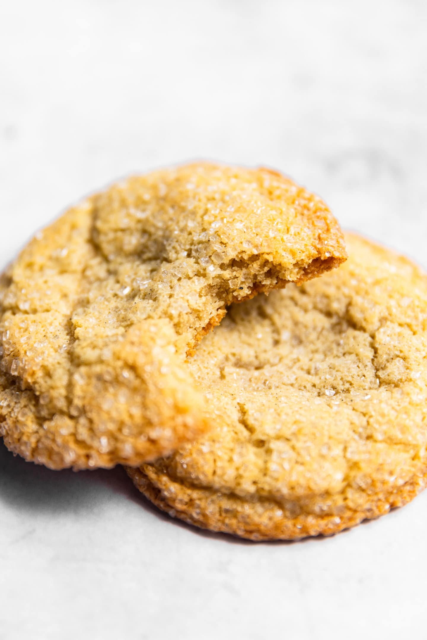 Close up of vanilla sugar cookie with a bite missing showing soft and chewy cookie interior.