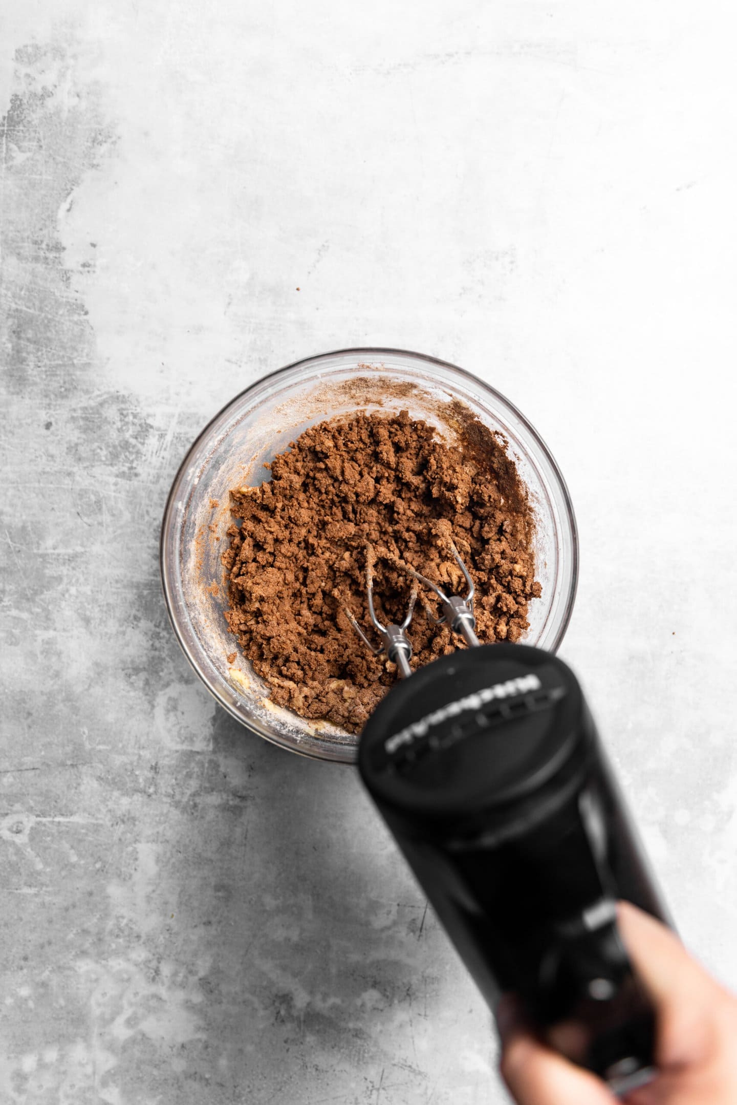 Dry ingredients being beaten into the wet to form chocolate sugar cookie dough