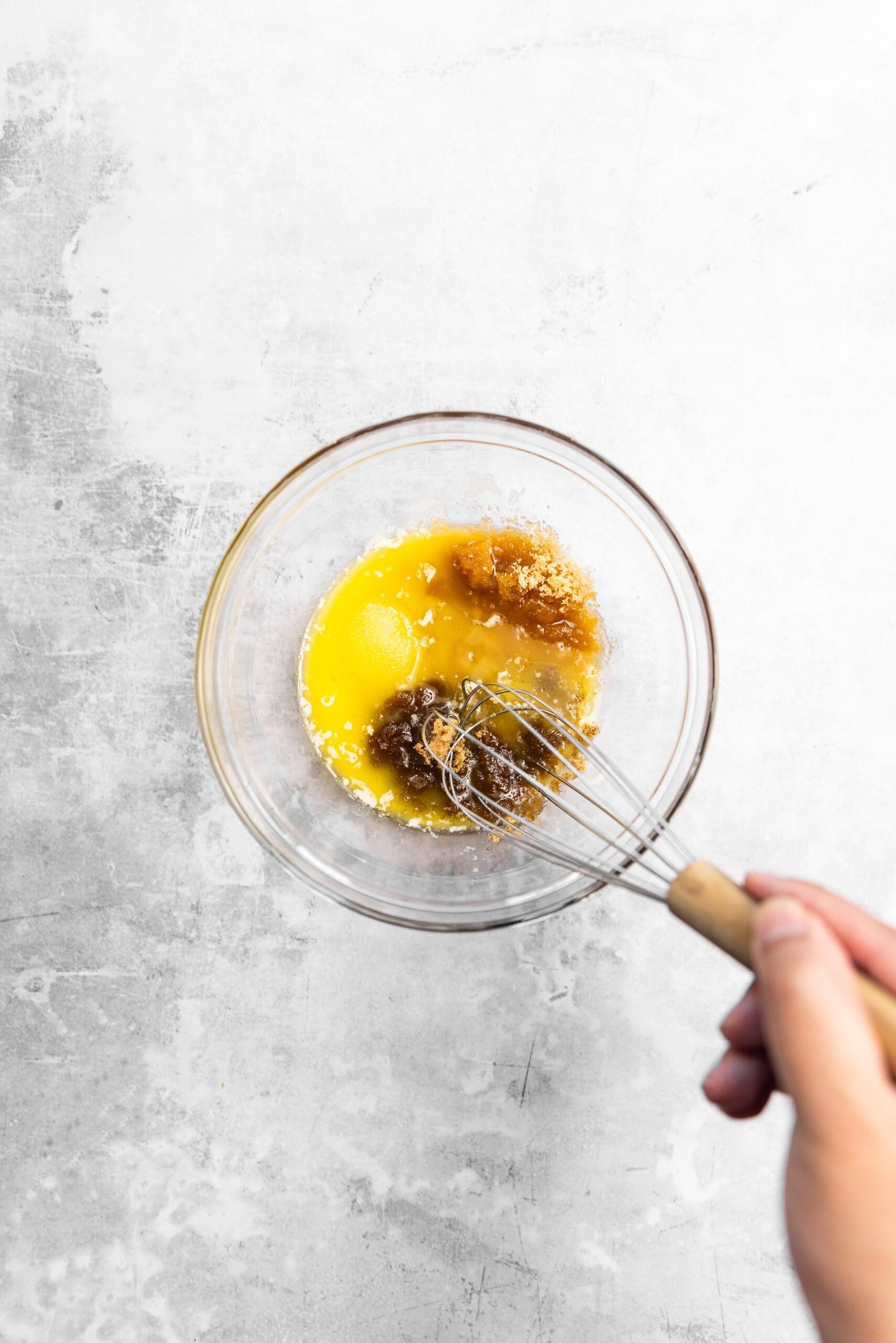 Melted butter and sugars being whisked together.