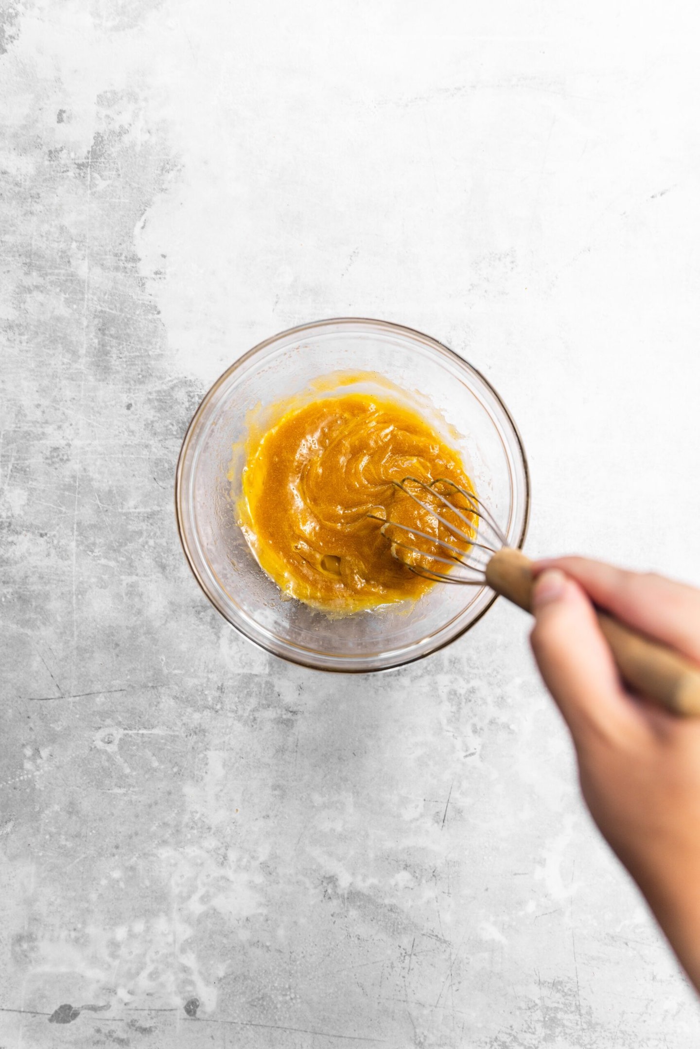 Egg being whisked into sugar mixture.