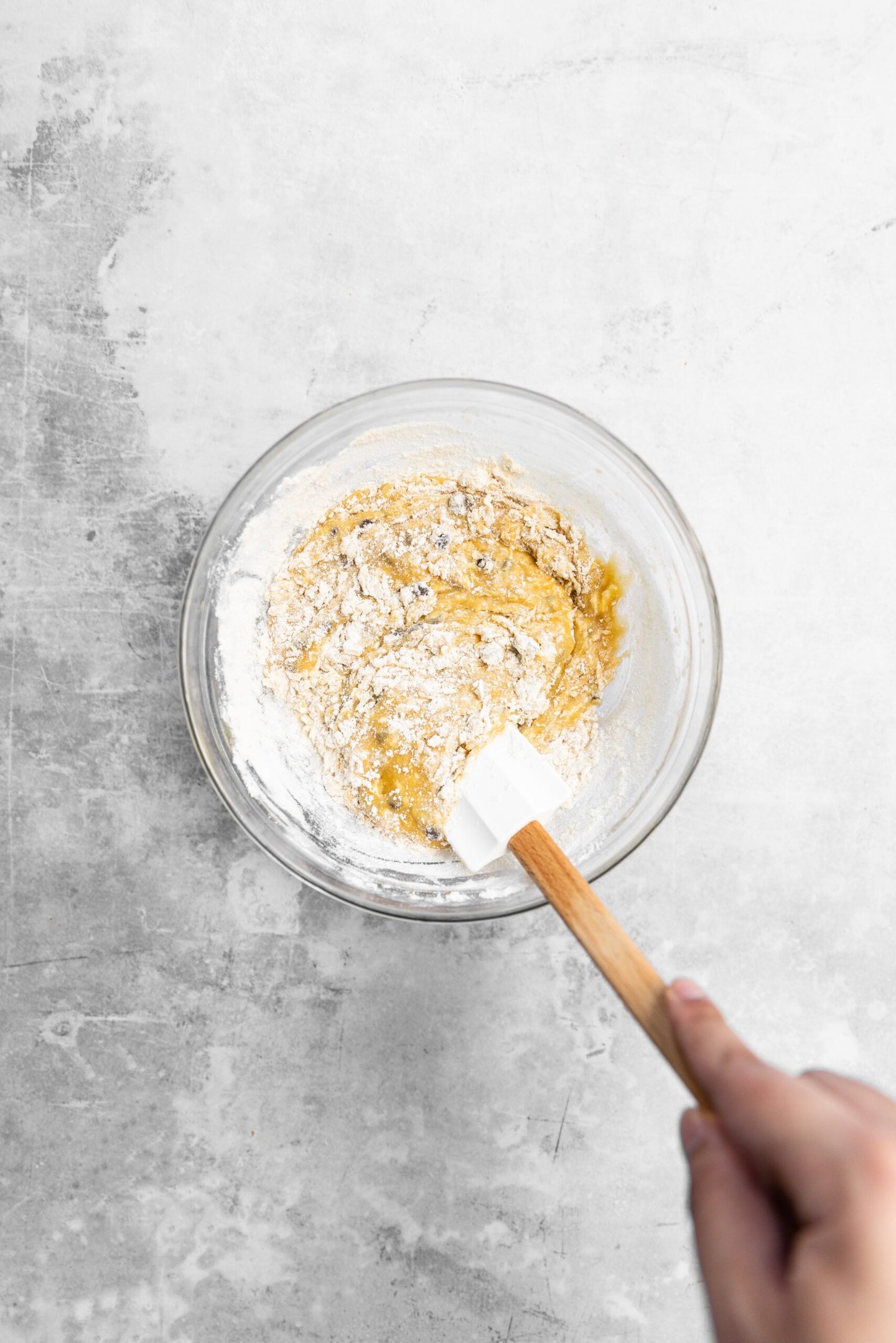 Dry ingredients and chocolate chips being stirred into blondie batter