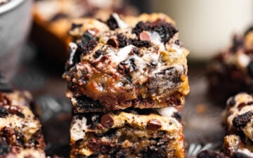 Gooey Small Batch Oreo Blondies stacked on top of each other next to a glass of milk