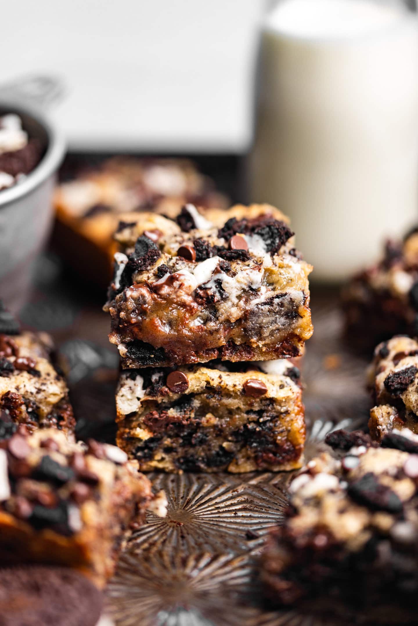 Gooey Small Batch Oreo Blondies stacked on top of each other next to a glass of milk