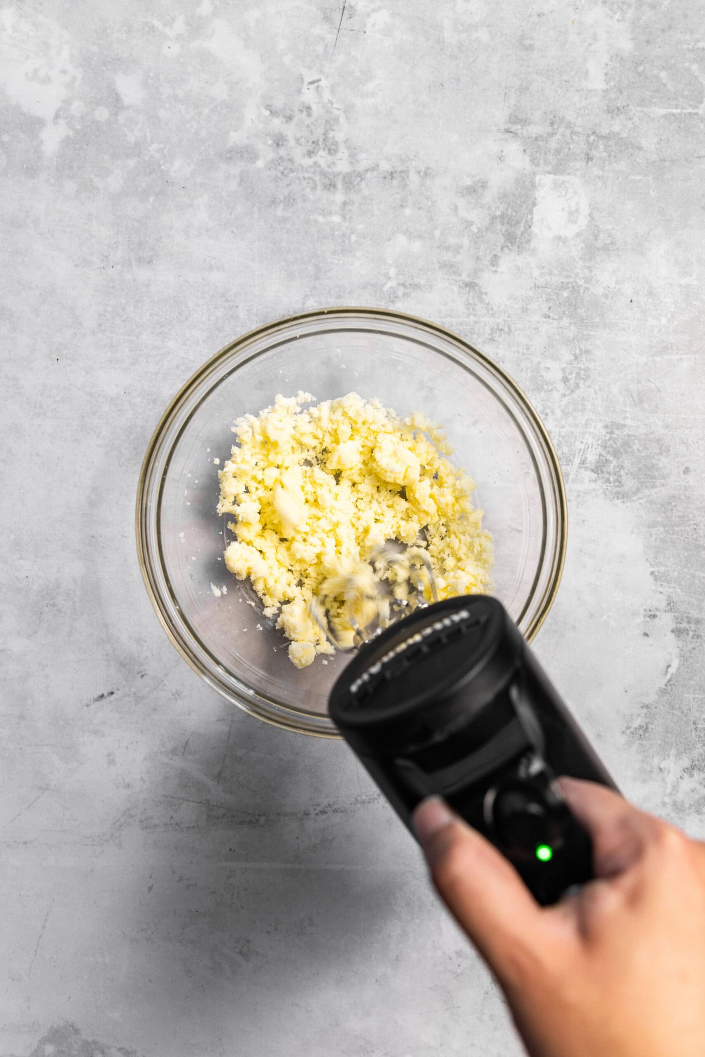 Butter and sugar being creamed together by a hand mixer