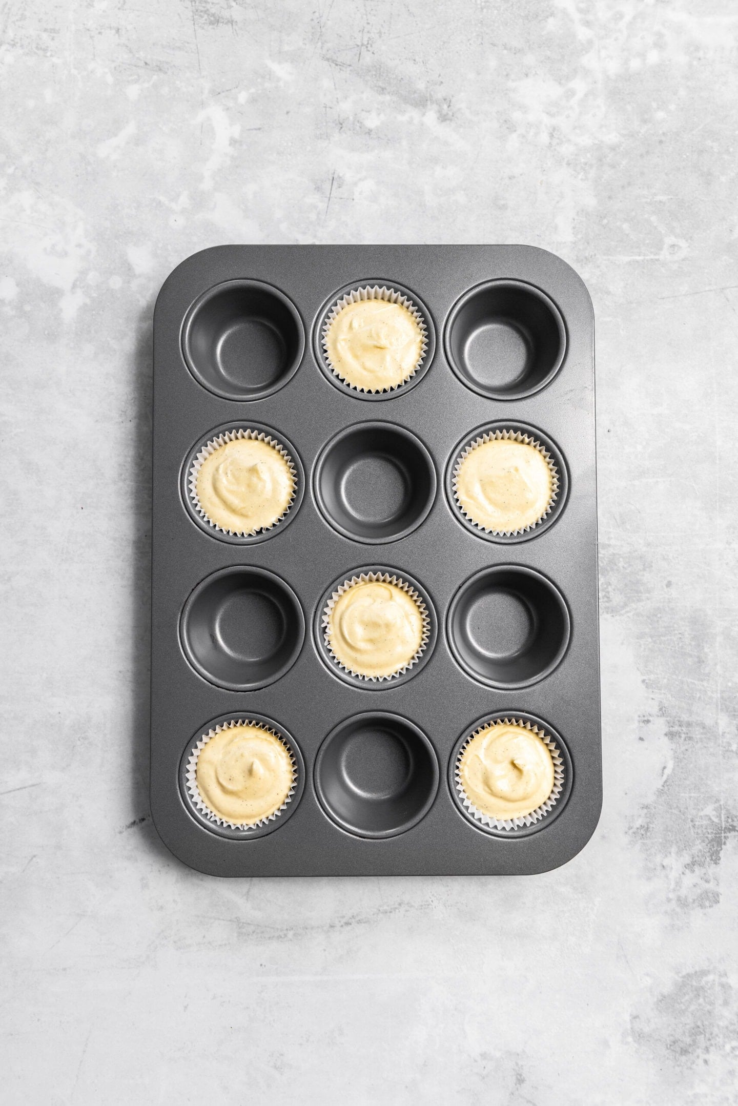 Cupcake batter in prepared muffin tin with smooth tops ready for the oven.