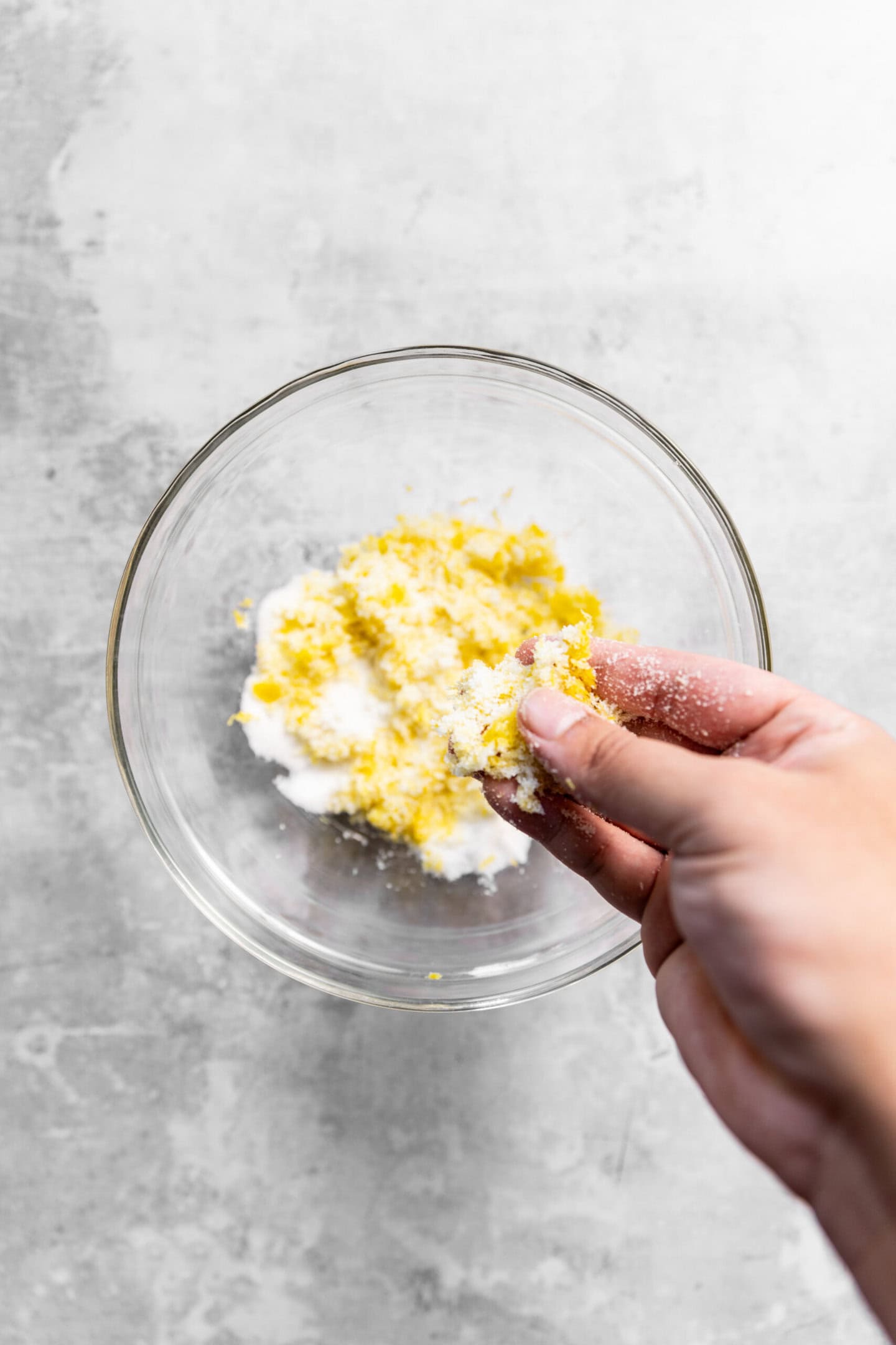 Lemon zest being rubbed into sugar to release oils