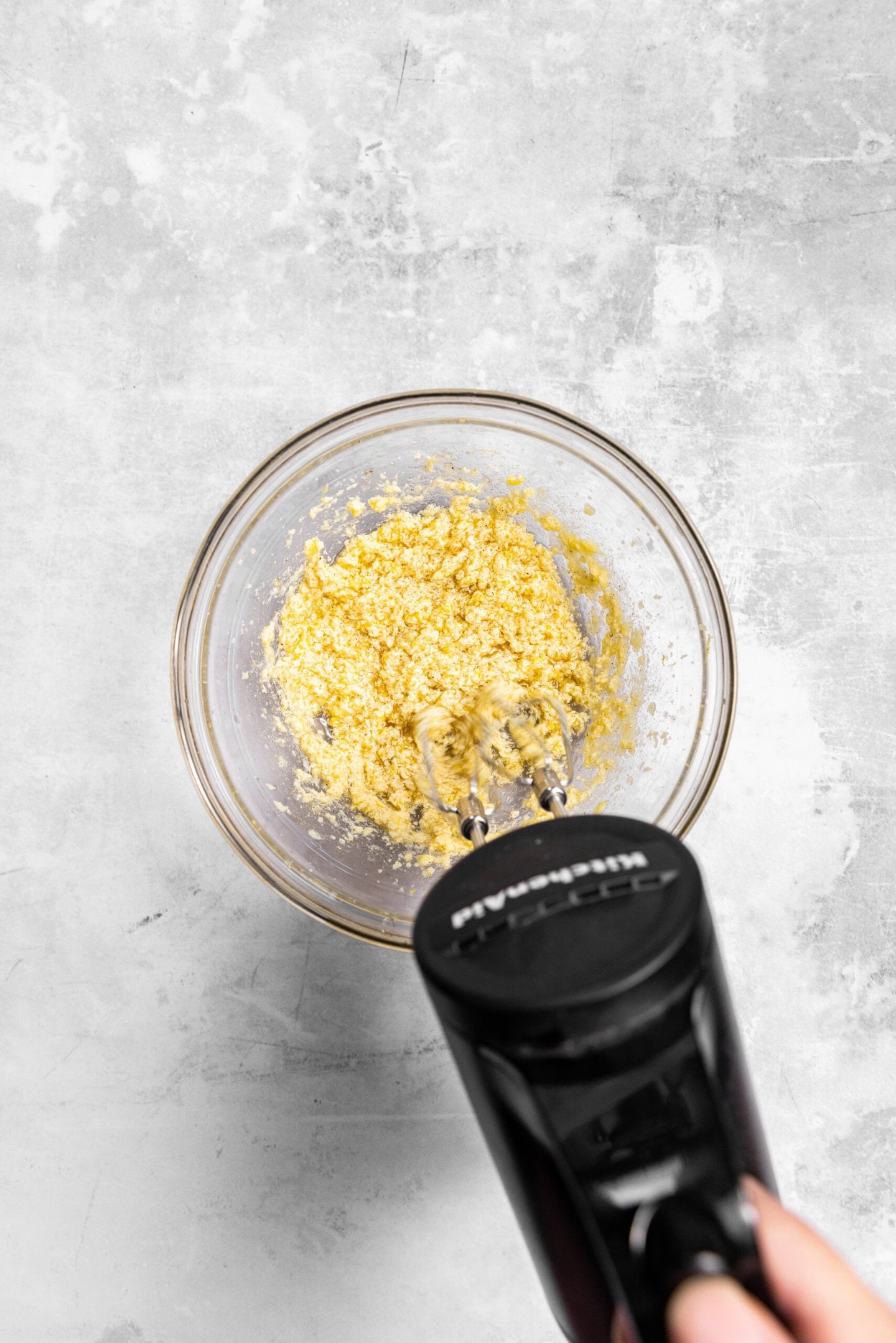 Wet ingredients being beaten into butter and sugar mixture