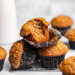 A stack of banana muffins with a bite missing from the top one.