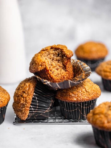 A stack of banana muffins with a bite missing from the top one.