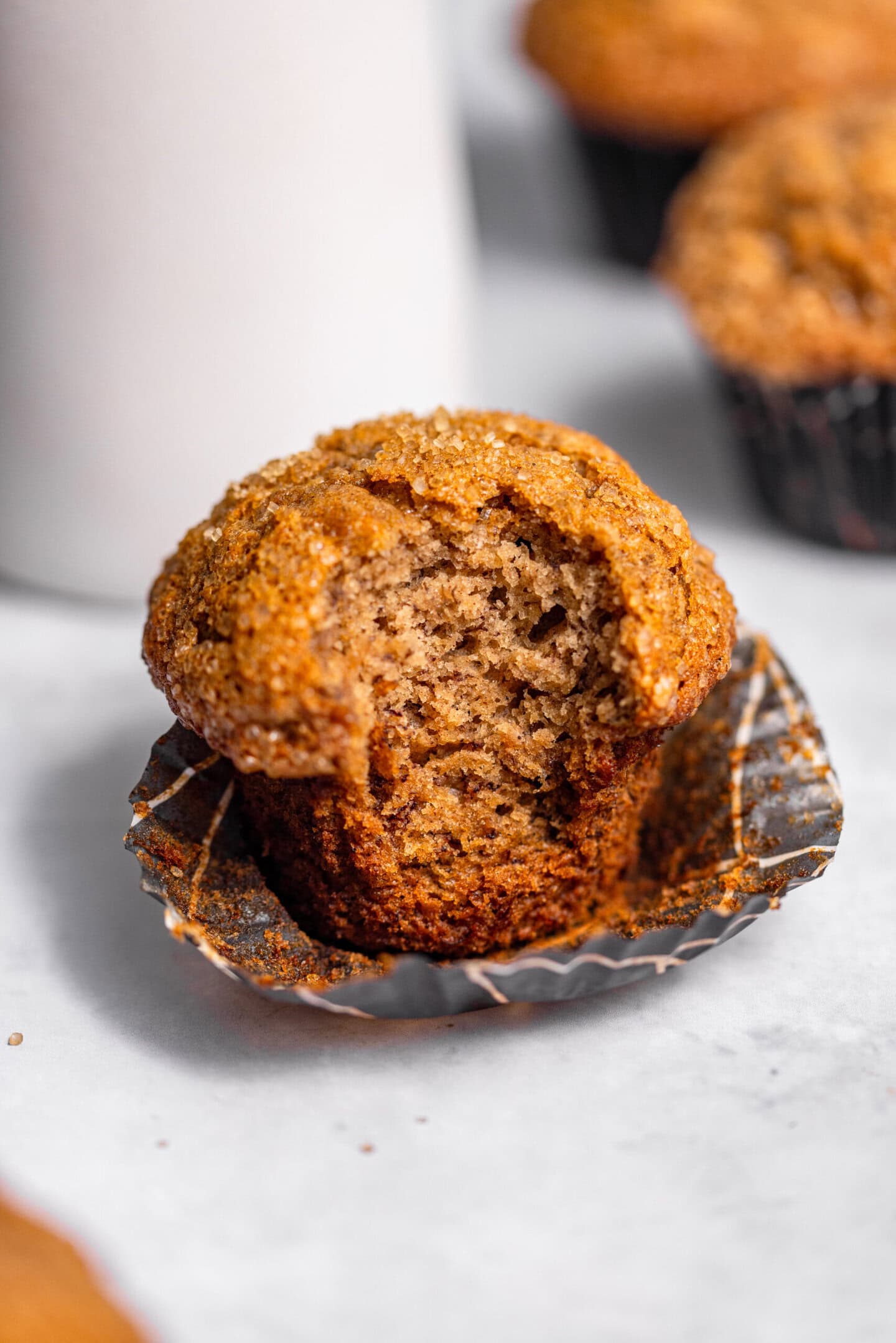 Close up of banana muffin with a bite missing showing moist and tender crumb interior