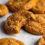 A close up of a molasses cookie with a bite missing showing its soft and chewy texture