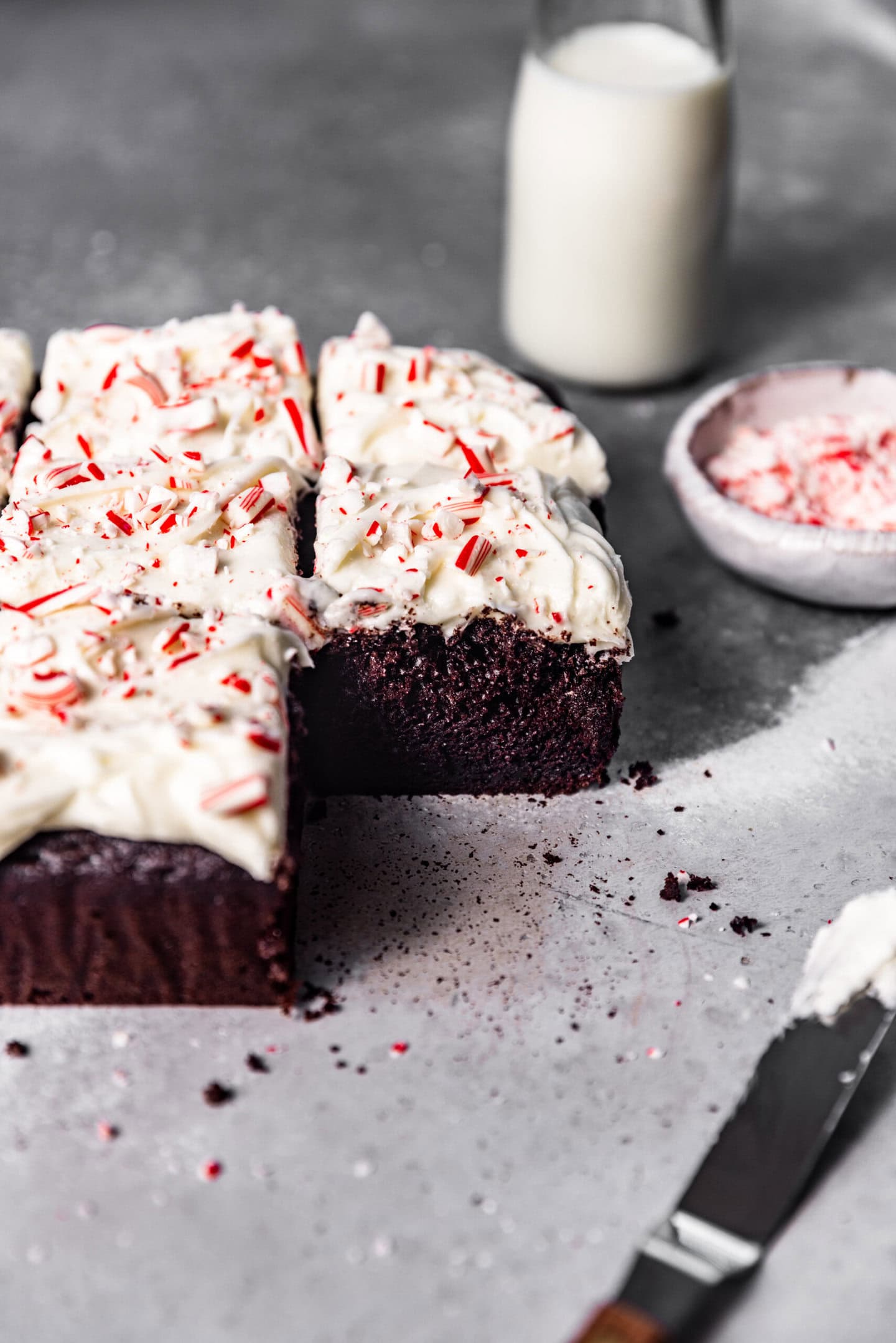 Moist interior of chocolate peppermint snack cake next to an icing spatula with peppermint cream cheese frosting on it.