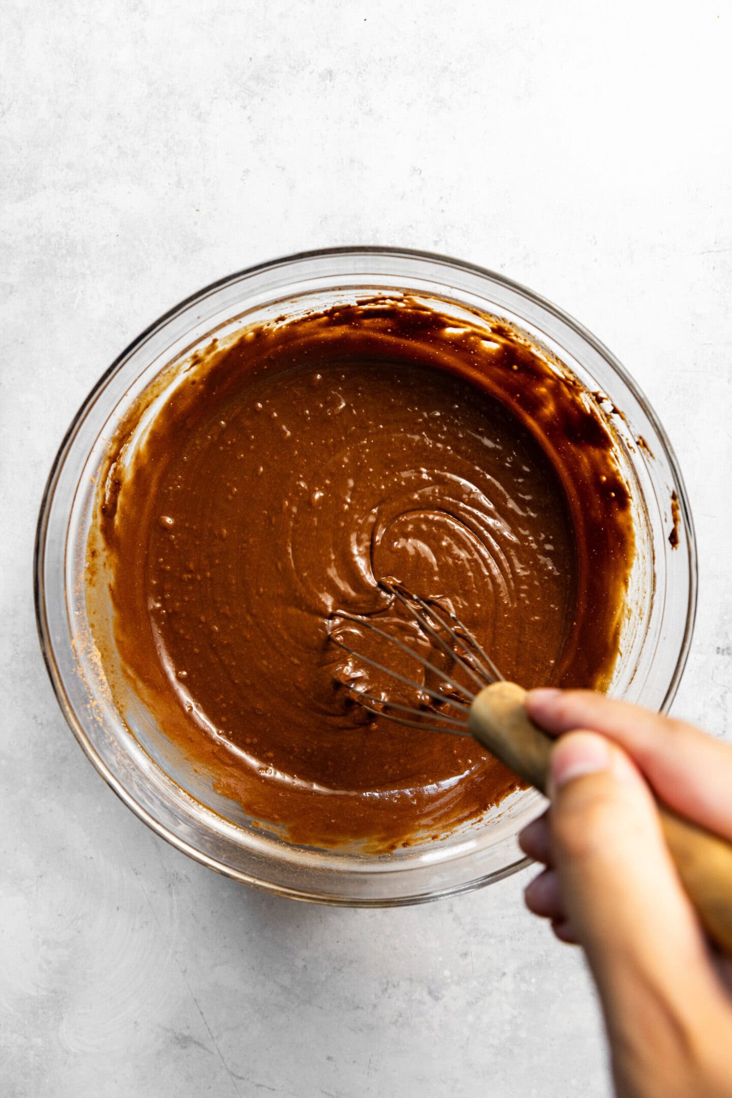 Coffee and peppermint extract being whisked into chocolate cake batter.