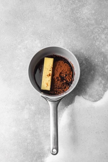 Butter, oil, and cocoa powder being combined in a saucepan.
