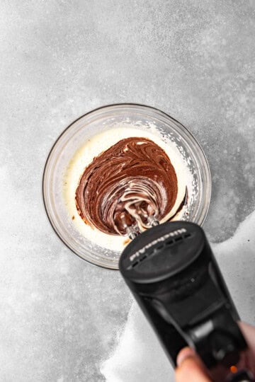 Melted cocoa mixture being incorporated into the egg and sugar mixture.